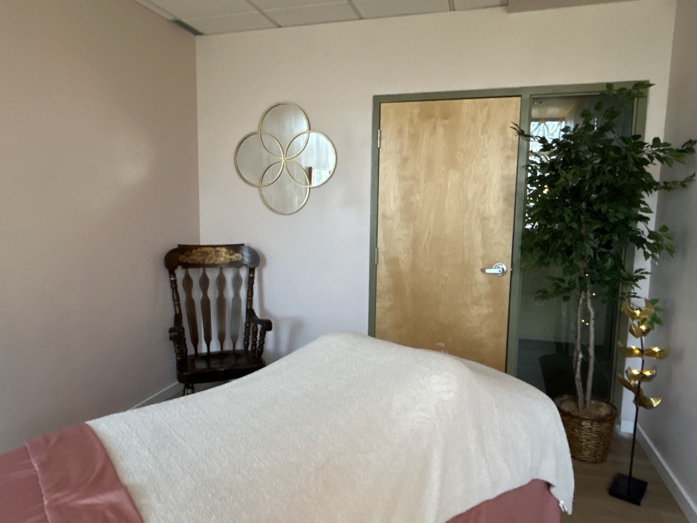 Another view of the studio: the table under a soft blanket, a rocking chair and a gold mirror